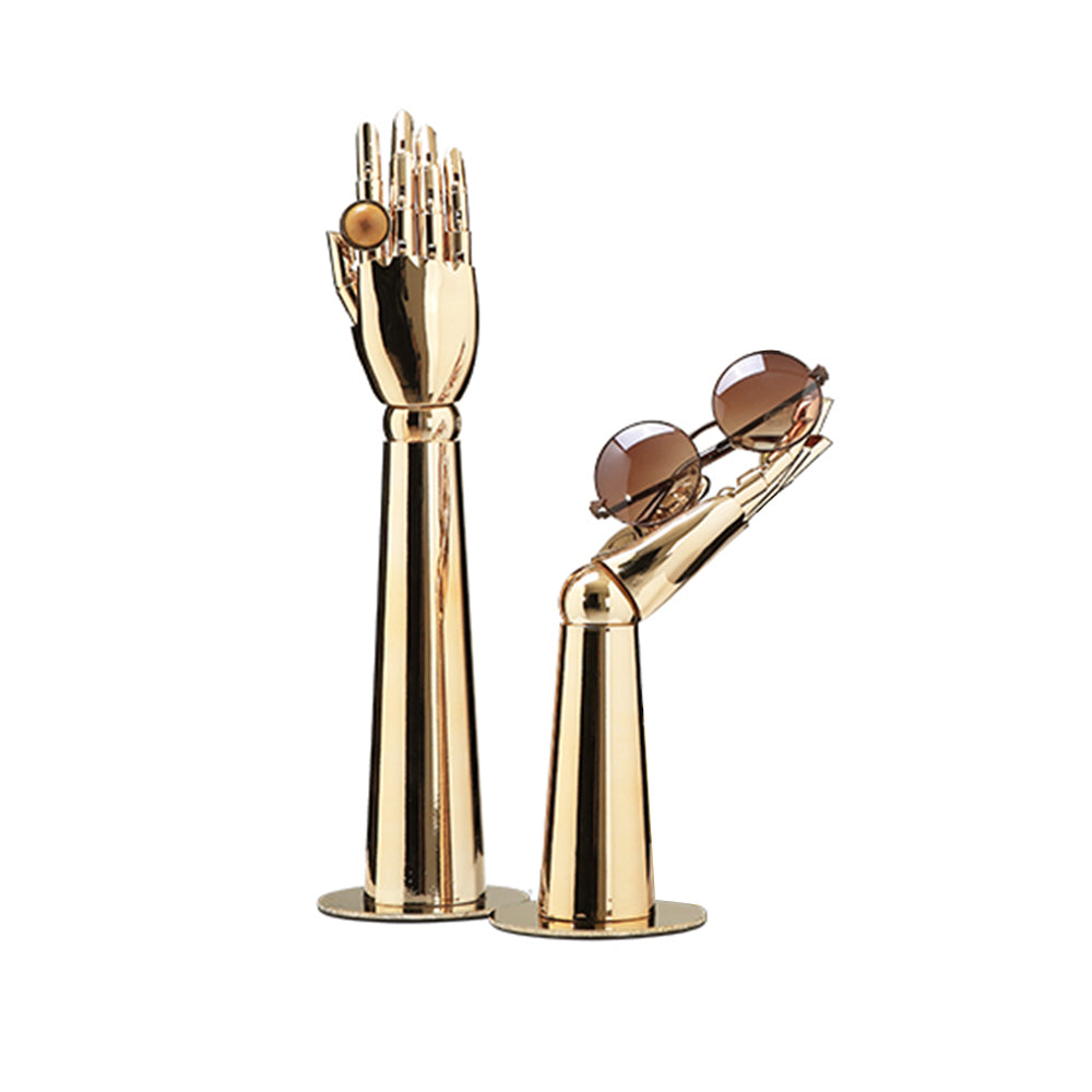 Two gold electroplated mannequin hand stands displaying sunglasses and a statement ring