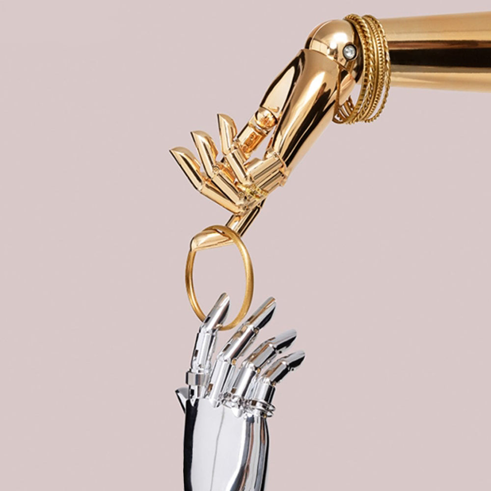 Close-up of gold and chrome silver articulated-style mannequin fingers displaying a bangle