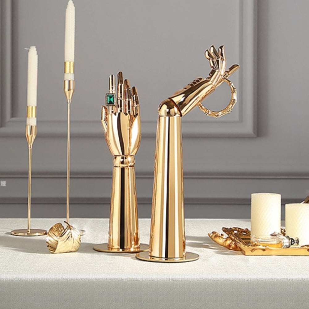 Gold mannequin hand display stands showcasing jewelry in a luxury boutique setting