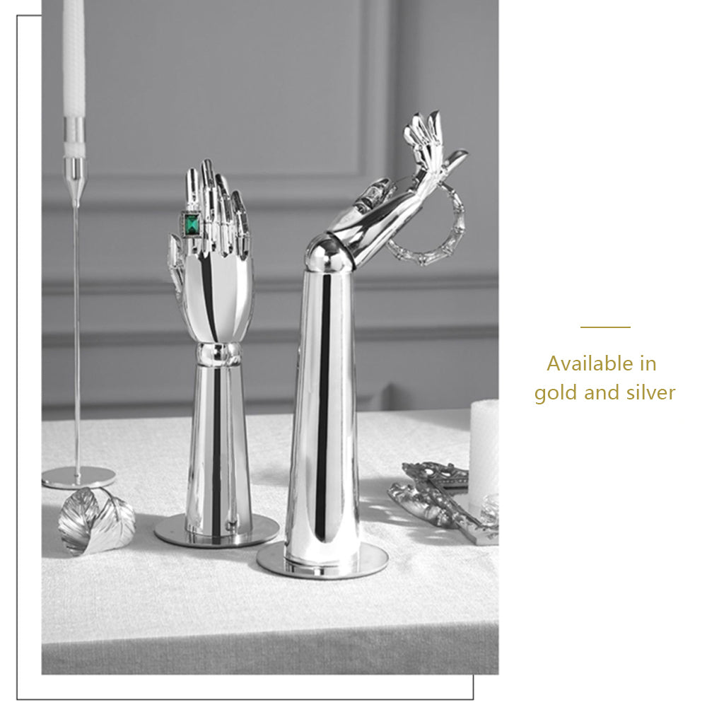 Two chrome silver mannequin hand display stands showcasing a ring and bracelet