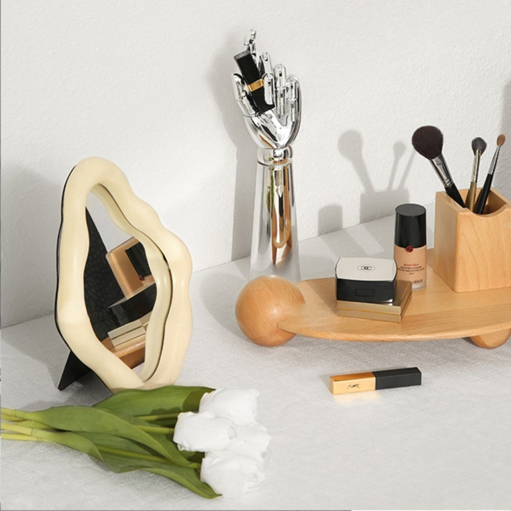 Chrome silver mannequin hand stand holding a cosmetic product on an elegant vanity