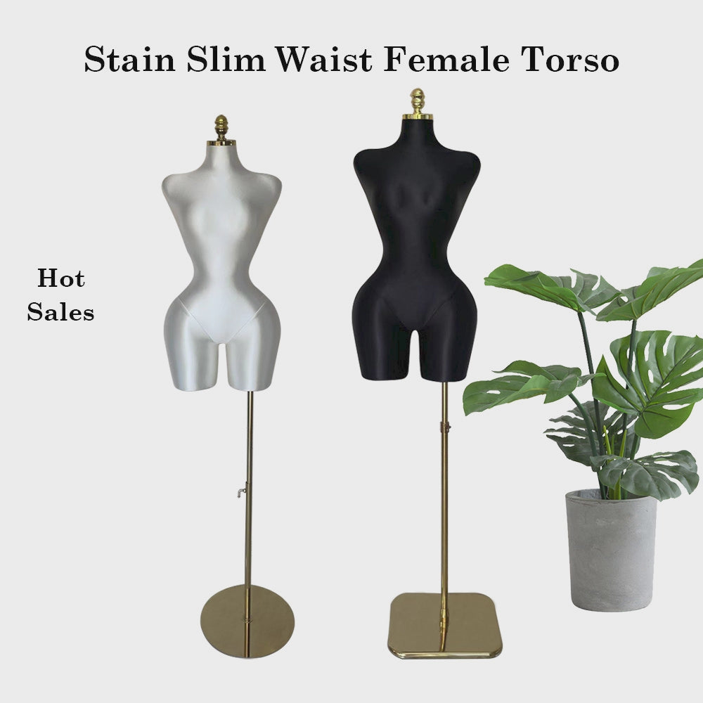 a pair of mannequins standing next to a potted plant